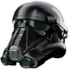Czarny hełm z serii Star Wars, z zielonymi wizjerami i detalami w postaci srebrnych elementów oraz przetarć. Hełm ma futurystyczny design z wyraźnymi liniami i teksturami.