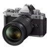 Aparat bezlusterkowy z widocznym logo "Nikon" na górnej części korpusu oraz oznaczeniem "Z f" z boku, wyposażony w obiektyw z napisem "NIKKOR Z 24-70mm 1:4 S Ø72". Korpus aparatu ma srebrne i czarne elementy z teksturą, a na górze znajdują się pokrętła i przyciski.