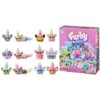 Na zdjęciu znajduje się zestaw figurek "HASBRO Furby Minis G19515L0", składający się z 12 kolorowych figurek o różnych wzorach i fryzurach, obok pudełka z napisem "Furby minis" oraz informacją o zawartości 12 figurek. Na pudełku widnieje ostrzeżenie: "WAR