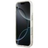 Przezroczyste etui na telefon z widocznymi złotymi drobinkami, zaprojektowane dla modelu iPhone 17, z wycięciami na przyciski i aparat. Na ekranie telefonu widoczny jest abstrakcyjny wzór z ciemnymi i jasnymi okręgami.