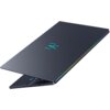 Na zdjęciu widoczny jest zamknięty laptop z ciemną obudową, na której znajduje się świecące logo w kształcie stylizowanej litery "M". Krawędzie laptopa mają delikatne, kolorowe podświetlenie.