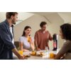 Na zdjęciu znajduje się saturator SODASTREAM Mix Czarny na blacie, obok którego leżą szklanki z napojami i talerz z przekąskami. W tle widać jasne wnętrze z dużymi oknami.
