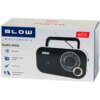 Pudełko z radiem przenośnym BLOW RA12 w kolorze czarno-srebrnym, z widocznymi funkcjami: Bluetooth, analogowe stacje AM/FM, jack 3.5 mm oraz zasilanie sieciowe lub bateryjne. Na opakowaniu znajduje się logo "BLOW" oraz oznaczenie "FM".