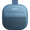 Niebieski głośnik mobilny z widocznym logo "BOSE" na górze, poniżej znajdują się przyciski sterujące: Bluetooth, minus, play/pauza, plus i zasilanie. Dolna część głośnika ma perforowaną powierzchnię, a u góry widoczny jest uchwyt z materiału.