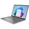 Na zdjęciu widoczny jest otwarty laptop z szarym korpusem, na ekranie którego wyświetlony jest pulpit systemu Windows 11 z ikonami aplikacji. Klawiatura jest pełnowymiarowa, a obudowa ma smukły design.