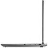Laptop widziany z boku, z otwartą pokrywą, ukazujący porty na krawędzi obudowy, w tym USB-C, gniazdo audio, przycisk oraz port USB-A. Obudowa jest w kolorze szarym, a ekran jest ustawiony pionowo.