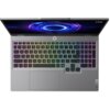 Na zdjęciu widoczny jest laptop z podświetlaną klawiaturą w kolorach tęczy oraz logo "Lenovo" na obudowie. Na ekranie wyświetlany jest abstrakcyjny, kolorowy wzór przypominający wir.