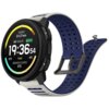 Na zdjęciu widoczny jest smartwatch z okrągłym wyświetlaczem, na którym pokazana jest godzina 19:36:54, data "SAT AUG 23", poziom naładowania baterii 92%, oraz informacje o pogodzie: "BROKEN CLOUDS 5°C". Pasek zegarka jest szaro-niebieski z perforacjami, 
