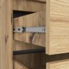Zbliżenie na fragment szafy w kolorze Dąb Artisan, ukazujące szczegóły drewnianej faktury oraz mechanizm prowadnicy szuflady. Widoczne są dwie szuflady, z których jedna jest częściowo wysunięta.