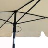 Beżowy parasol ogrodowy z metalowym stelażem i mechanizmem do regulacji wysokości. Widoczne są czarne pręty wspierające oraz fragment materiału parasola.