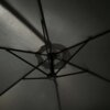 Zdjęcie przedstawia wewnętrzną stronę ciemnoszarego parasola ogrodowego z widocznymi metalowymi prętami konstrukcji. Materiał parasola jest lekko oświetlony, co podkreśla jego teksturę.
