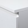 Zbliżenie na biały, matowy mebel z prostokątnym blatem i widoczną krawędzią szuflady. Mebel ma gładką powierzchnię i minimalistyczny design.