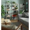 Na zdjęciu znajduje się wnętrze salonu z dwoma regałami w stylu loftowym, wypełnionymi książkami, roślinami i dekoracjami. Obok regałów stoi szara sofa, a na ścianie wisi plakat z napisem "SAN FRANCISCO".