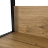 Zbliżenie na fragment regału industrialnego z metalową ramą w kolorze czarnym i półką w kolorze dębu artisan o matowym wykończeniu. Widoczna jest tekstura drewna z naturalnymi sękami i słojami.