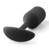 Czarny korek analny o gładkiej powierzchni, z widocznym logo "b-Vibe" na podstawie. Produkt ma ergonomiczny kształt z zaokrąglonymi krawędziami.