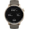Złoty smartwatch z ciemnym wyświetlaczem pokazuje dane: "ŚREDNIE TEMPO 8'42"/KM", "RYTM 174 SPM", "DŁUGOŚĆ 72 CM", "Kcal 265". Pasek zegarka jest ciemny, a na tarczy widoczne są oznaczenia minutowe.