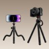 Na zdjęciu widoczne są dwa statywy z elastycznymi nogami, jeden z zamocowanym smartfonem, a drugi z aparatem fotograficznym. Na statywie z aparatem widoczny jest napis "MT30".