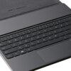 Na zdjęciu widoczna jest klawiatura z czarnymi klawiszami, w tym klawisze funkcyjne i alfanumeryczne, oraz touchpad poniżej. W tle znajduje się ciemne etui z napisem "Made in Dream".