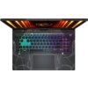 Laptop z podświetlaną klawiaturą w różnych kolorach, widziany z góry, z widocznym logo producenta na górnej części obudowy. W tle widać elementy konstrukcyjne i podświetlenie w odcieniach pomarańczowych.
