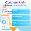 Opakowanie suplementu diety "Calcium kids" z grafiką żyrafy i pomarańczowym klinem, zawiera informacje o składnikach: wapń, witamina D3 i cynk, oraz ich korzyściach dla zdrowia kości i zębów. Widoczny jest napis "Zdrowy rozwój dziecka" oraz informacja "Smak pomarańczowy".