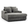Szara sofa z weluru o pluszowej teksturze, z widocznymi wypukłymi wzorami przypominającymi plastry miodu. Na sofie znajdują się trzy poduszki w tym samym stylu i kolorze.