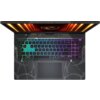 Na zdjęciu widoczny jest laptop z podświetlaną klawiaturą w różnych kolorach, z wyraźnym wzorem na obudowie wokół klawiatury. Na ekranie laptopa znajduje się logo producenta z efektem świetlnym w odcieniach pomarańczowych.