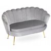 Szara sofa dwuosobowa w stylu glamour z oparciem w kształcie muszli i złotymi, smukłymi nogami. Tapicerka jest gładka, a siedzisko ma zaokrąglony kształt.