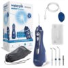 Na zdjęciu znajduje się granatowy irygator bezprzewodowy z białymi elementami, cztery końcówki, kabel USB, etui oraz woreczek z napisem "waterpik waterflosser". Obok widoczne jest pudełko z grafiką irygatora i napisami: "waterpik waterflosser", "CORDLESS 