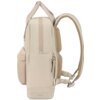 Beżowy plecak z materiału, z widocznymi kieszeniami i zamkami błyskawicznymi, posiada regulowane szelki oraz uchwyt do noszenia. Na dole plecaka znajduje się napis "AMERICAN TOURISTER".