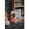 Na zdjęciu znajduje się opakowanie napoju "BARÚ Pumpkin Spice Latte with coffee & exotic spices" ustawione na drewnianej desce obok filiżanki z napojem i dekoracyjnych dyni. W tle widoczna jest półka z przyprawami w słoiczkach.