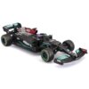 Zdalnie sterowany model samochodu wyścigowego w kolorze czarnym z turkusowymi i czerwonymi akcentami, z widocznymi logotypami "PETRONAS", "AMG", "IWC" oraz "INEOS". Opony mają żółte napisy "P ZERO", a na karoserii znajdują się różne detale i oznaczenia sponsorów.