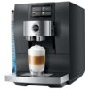 Czarny ekspres do kawy z wyświetlaczem dotykowym, na którym widoczne są opcje: Espresso, Coffee, Lungo, Cappuccino. Na ekspresie znajduje się logo "jura" oraz napis "Z10", a poniżej przygotowywana jest kawa z mleczną pianką w szklance.