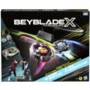 Opakowanie zestawu "Beyblade X" z grafiką dwóch wirujących bączków na arenie, z widocznymi napisami: "XTREME BATTLE SET", "DAGGER DRAN 4-60R", "TUSK MAMMOTH 3-60T" oraz logo producenta Hasbro. W lewym dolnym rogu znajdują się postacie dwóch osób w dynamic