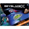 Opakowanie zestawu "Beyblade X" z grafiką dwóch wirujących bączków i napisem "Drop Attack" oraz logotypem Hasbro. Na dole widoczne są napisy: "Drop Attack Battle Set", "Impact Drake 9-60LR", "Hover Wyvern 3-85N" i oznaczenie wiekowe 8+.