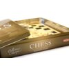 Metalowe pudełko z napisem "Collection Classique" i "CHESS WOODEN GAME" zawiera planszę do gry w szachy oraz logo "TACTIC". Wewnątrz widoczne są zapakowane figury szachowe na tle planszy.