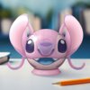Na zdjęciu znajduje się różowa kula z puzzli 3D, przedstawiająca postać z dużymi uszami i oczami, umieszczona na podstawce. Na pierwszym planie widoczny jest ołówek, a w tle rozmyte książki.