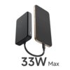 Na zdjęciu widoczny jest szary powerbank z podłączonym smartfonem za pomocą krótkiego kabla. Na dole zdjęcia znajduje się napis "33W Max".