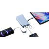 Jasnoniebieski powerbank z napisem "67W MAX" jest podłączony do trzech urządzeń za pomocą kabli USB. Na ekranie jednego z urządzeń widoczny jest wskaźnik ładowania z wartością "25%".