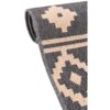 Zdjęcie przedstawia fragment zrolowanego dywanu zewnętrznego w kolorze brązowym z geometrycznym wzorem w odcieniach beżu i szarości. Struktura materiału jest wyraźnie widoczna, a brzegi dywanu są starannie obszyte.