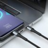 Na zdjęciu widać czarny kabel USB-C podłączony do laptopa oraz smartfona, na którym wyświetla się napis "Charging 78%". Kabel ma plecioną osłonę i metalowe końcówki, a laptop ma srebrną obudowę z widocznymi otworami wentylacyjnymi.