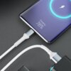 Na zdjęciu widać biały kabel USB podłączony do smartfona, na którego ekranie wyświetla się napis "Charging. 78%". Kabel jest podłączony do czarnego adaptera z niebieskim podświetleniem.