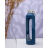 Niebieskie etui na butelkę o pojemności 1000 ml z białym uchwytem, z widocznym logo "Wessper" na przezroczystej części. W tle rozmyte kształty i fragmenty suszonych roślin.