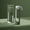 Zielone etui na butelkę o pojemności 500 ml z białym napisem "wessper" oraz "B1 BOROSILICATE" na opakowaniu. Obok znajduje się butelka z oliwkowym etui i białą zakrętką z uchwytem, z widocznym logo "wessper".