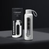 Na zdjęciu znajduje się biała butelka szklana z uchwytem oraz czarne opakowanie z napisem "wessper Motivational glass bottle 0,5 l WHITE" i "B1 BOROSILICATE". Na butelce widoczne są oznaczenia poziomu płynu oraz logo "wessper".