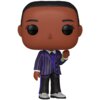 Na zdjęciu znajduje się figurka w stylu Funko Pop, przedstawiająca postać w fioletowo-czarnym, prążkowanym garniturze, trzymającą w ręku mały przedmiot. Postać ma duże, czarne oczy i krótkie, ciemne włosy.