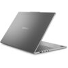 Szary laptop z widocznym logo "Lenovo" na pokrywie, częściowo otwarty, ukazujący klawiaturę i porty boczne. Na obudowie znajduje się naklejka z logo "AMD Ryzen 7".