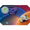 Ilustracja przedstawia kosmiczną scenę z szarym, kulistym obiektem z zielonym detalem oraz szarym statkiem kosmicznym z żółtymi elementami, na tle gwiazd i planet. W tle widoczne są kolorowe, geometryczne kształty oraz fragmenty przestrzeni kosmicznej z a