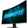 Zakrzewiony monitor z wyświetlaczem pokazującym niebieski napis "GIGABYTE" na tle dynamicznej grafiki. Na dolnej ramce monitora znajduje się logo "GIGABYTE".