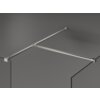 Przedstawiono fragment ścianki prysznicowej z przezroczystego szkła, z metalowymi wspornikami w kolorze niklu szczotkowanego. Konstrukcja ma prosty, nowoczesny design, a elementy metalowe są połączone w kształt litery "T".