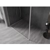 Na zdjęciu znajduje się ścianka prysznicowa typu walk-in z ramką, ustawiona na szarej, marmurowej podłodze, z ciemnymi, geometrycznymi płytkami na ścianie. Obok ścianki widoczny jest czarny stolik z butelką i ręcznikiem.